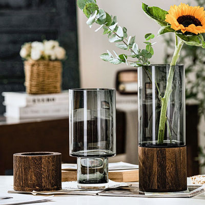 Vase aus transparentem Glas mit solidem Holzsockel