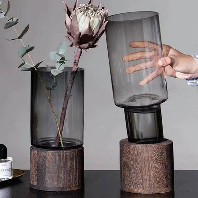 Vase aus transparentem Glas mit solidem Holzsockel